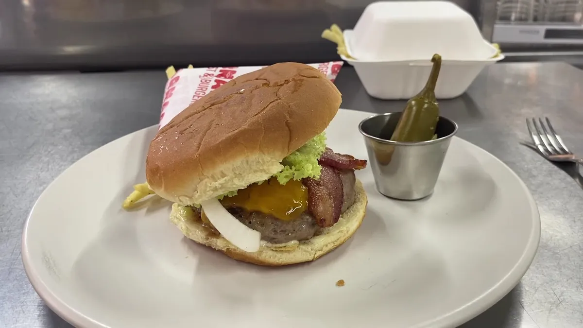 Hamburguesa con queso y tocino y un chile en vinagre