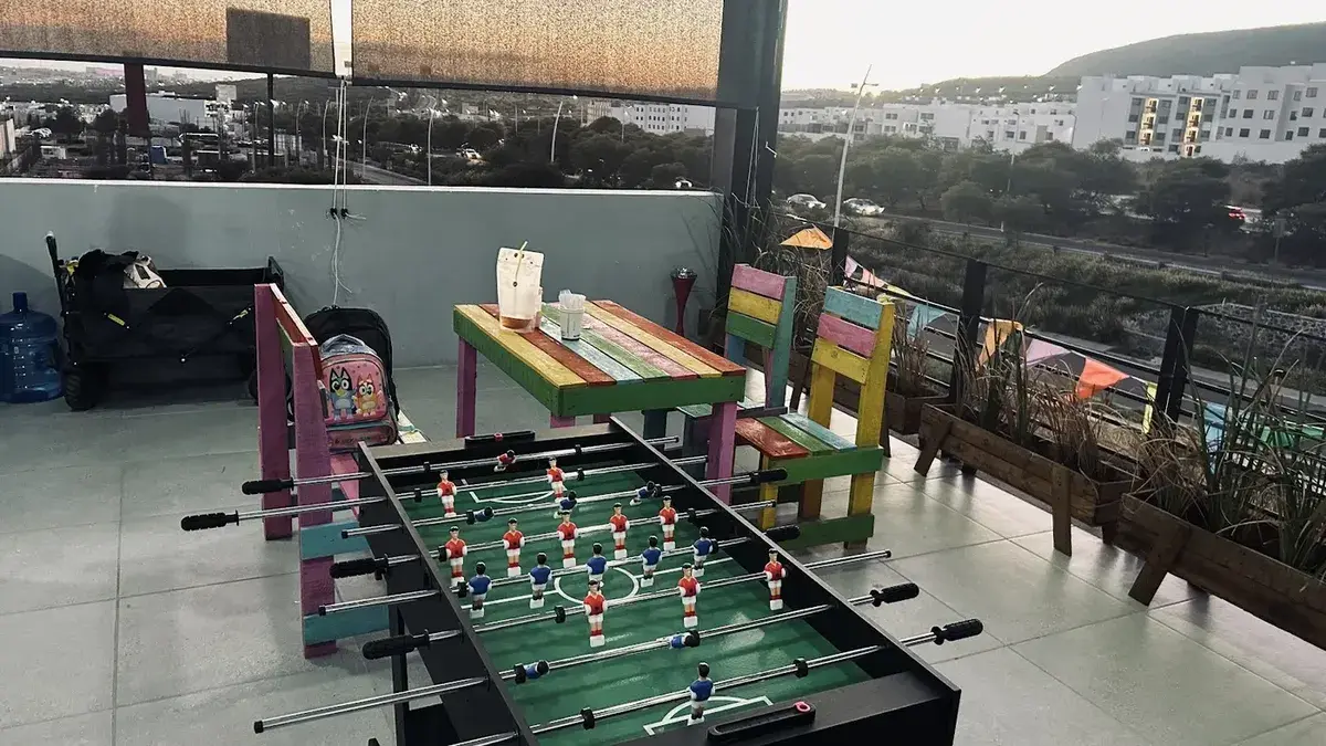 Terraza con futbolito y mesas de madera pintadas
