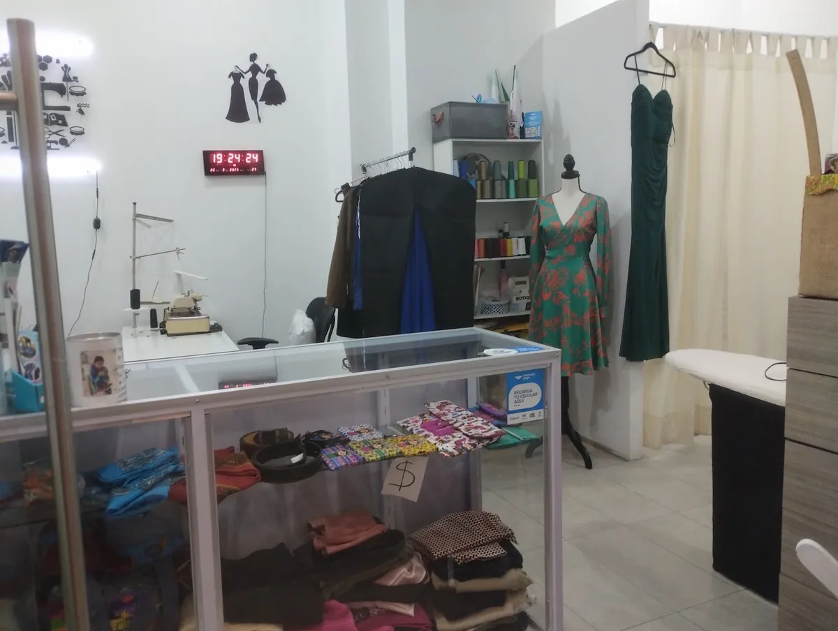 Mostrador del taller con máquina de coser y prendas