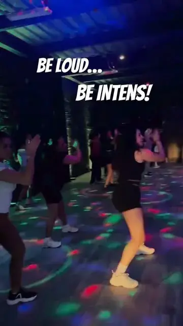 Grupo que baila entre luces de colores con el texto «Be loud... be intens!»