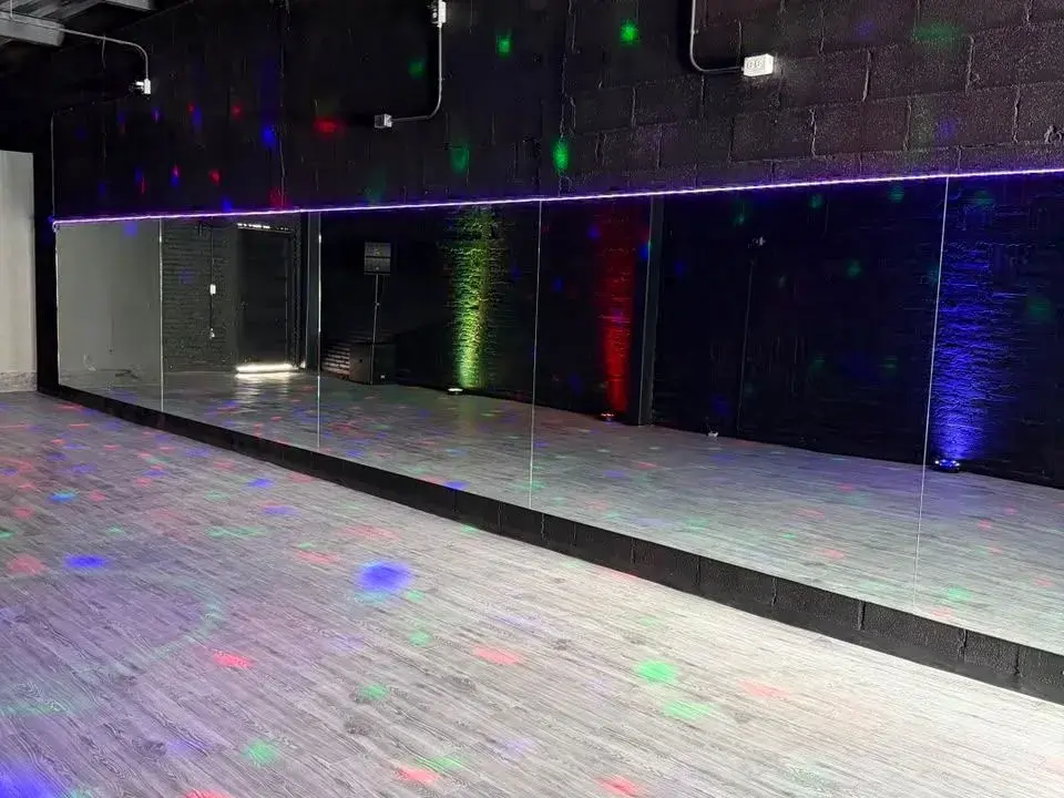 Salón con pared de espejos y luces de colores