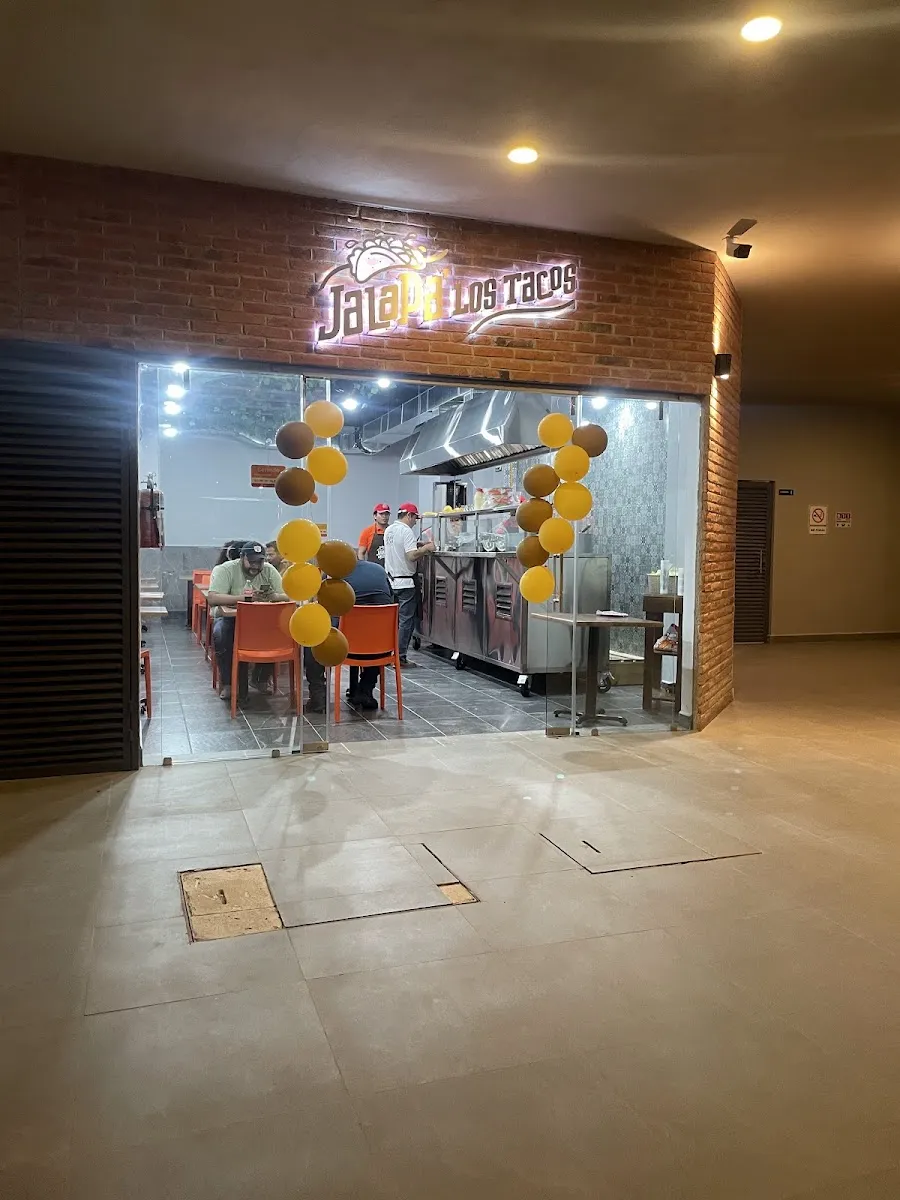 La entrada de JalaPa' Los Tacos con su letrero iluminado
