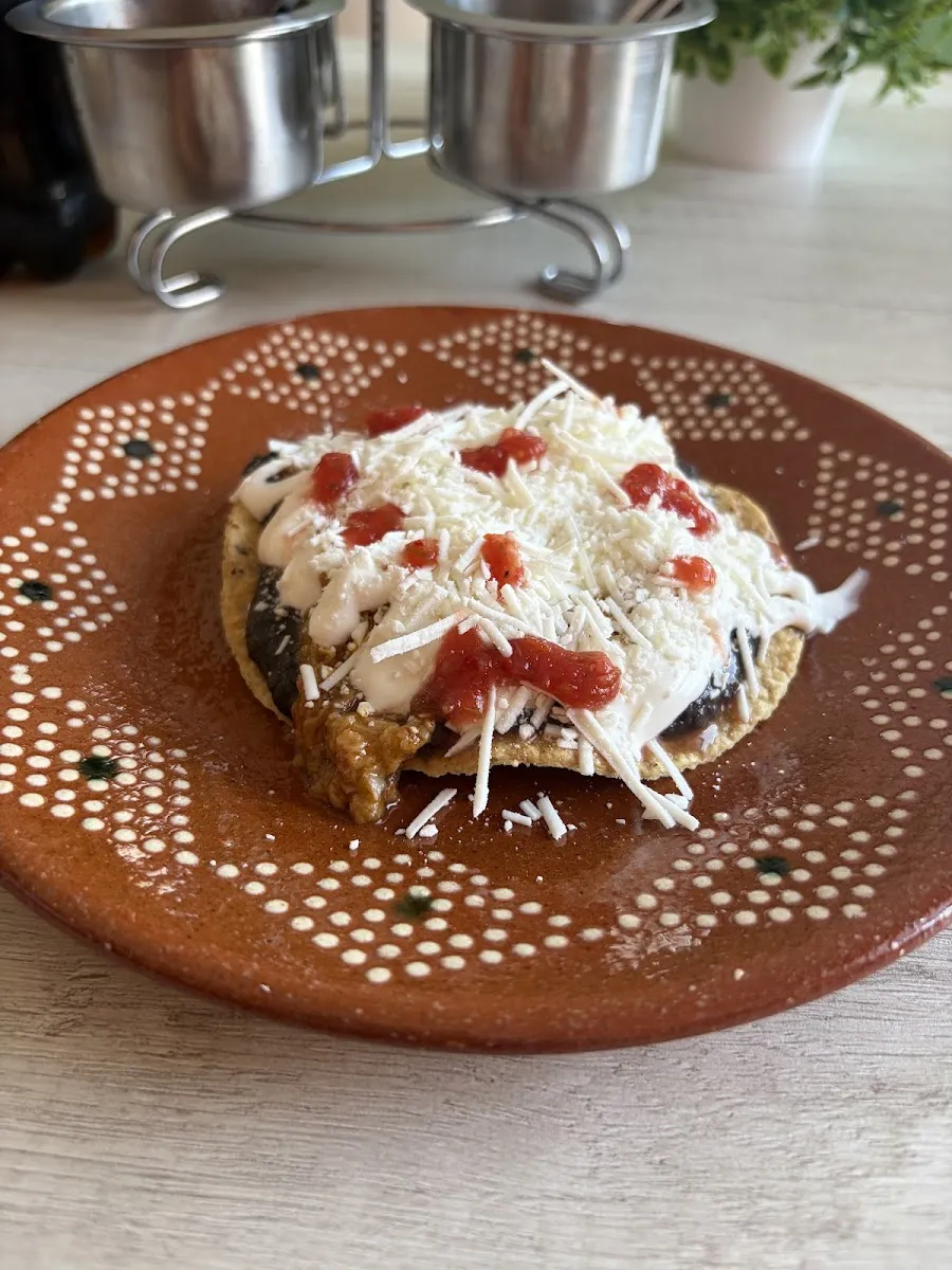 Tostada con crema y queso en plato de barro