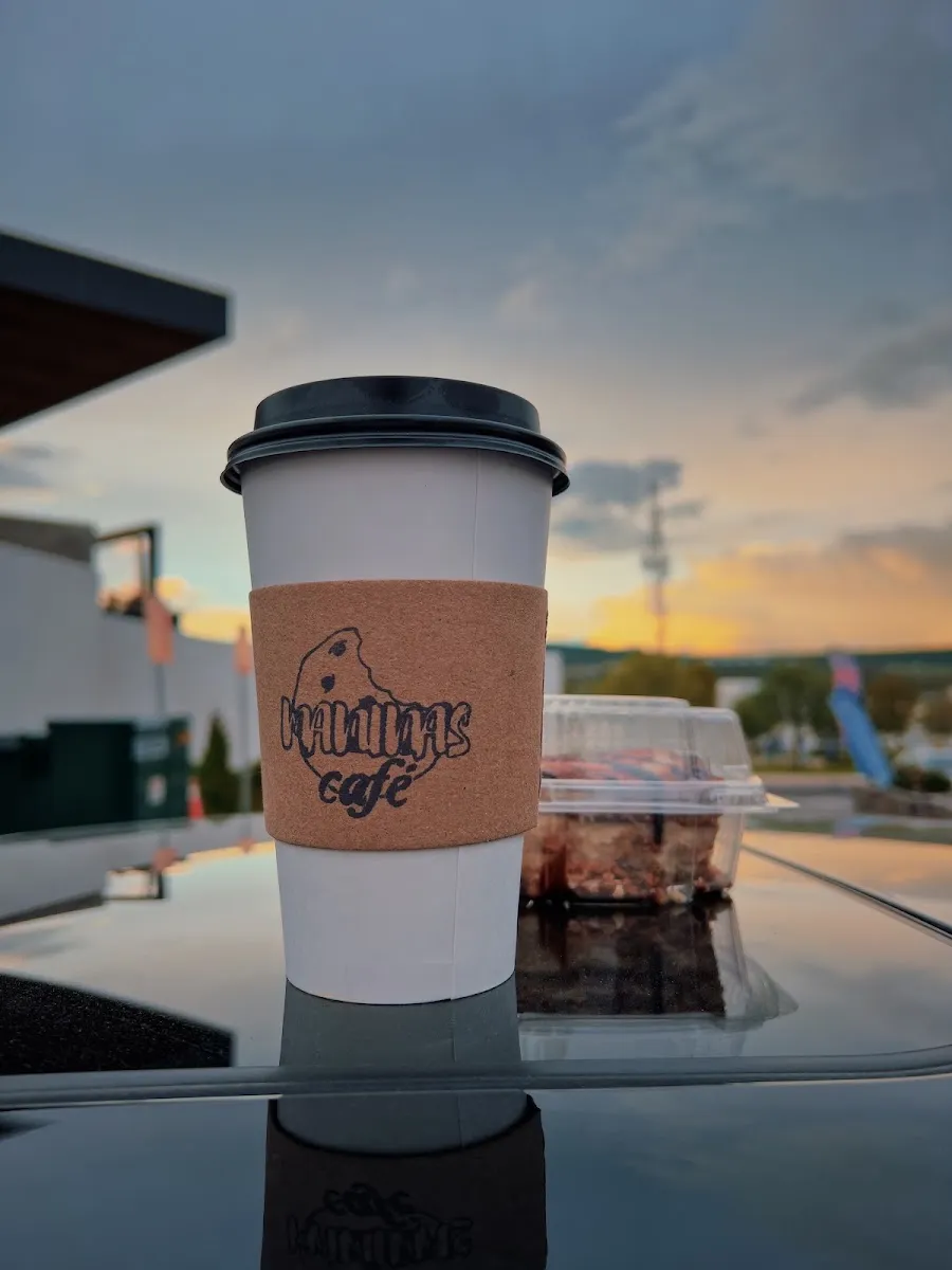Vaso de café de Maninas en la terraza al atardecer
