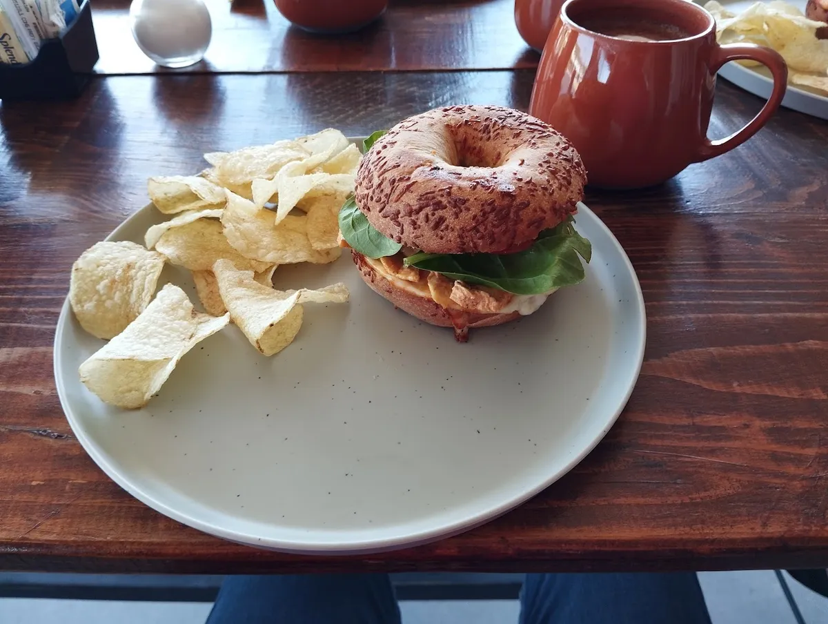 Bagel con pollo, lechuga y jitomate, con papas