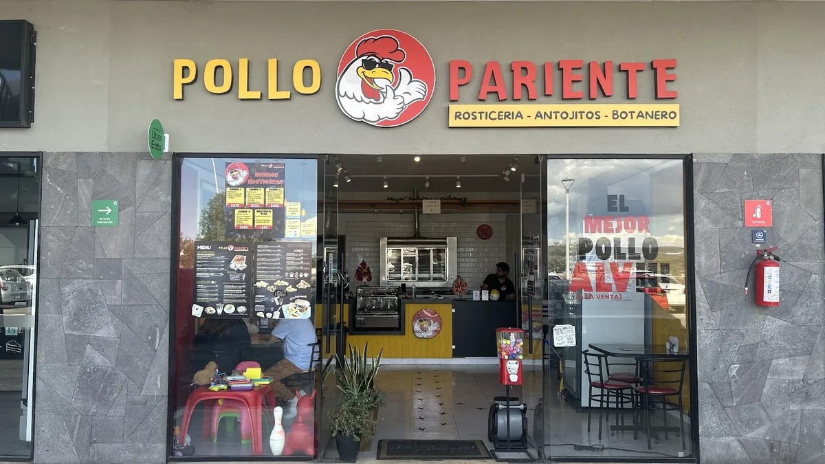 La entrada de Pollo Pariente con su letrero amarillo y rojo