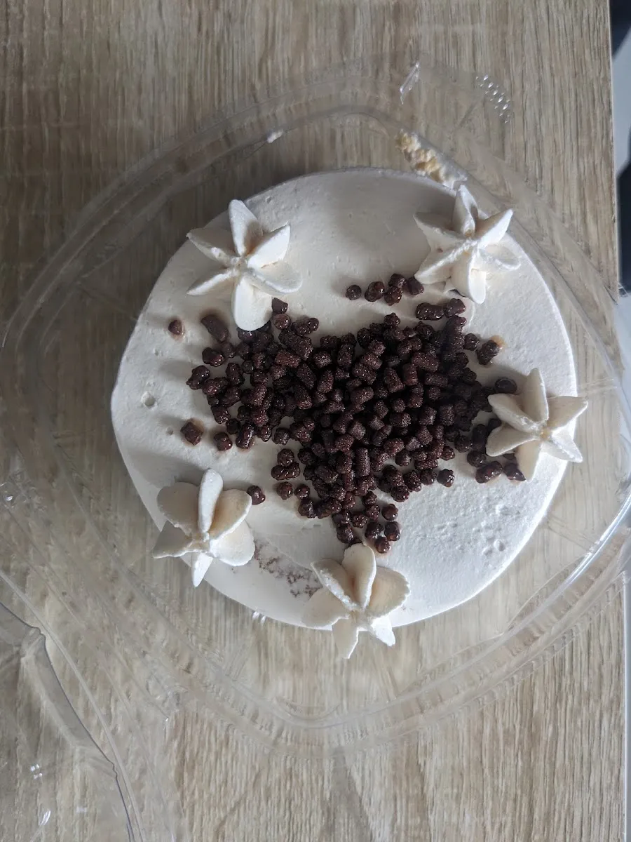 Pastel blanco con chispas de chocolate y flores de betún